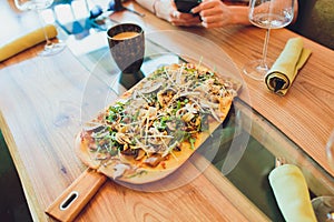 Italian fast food. Delicious hot pizza sliced and served on wooden platter with ingredients, close up view. Menu photo.