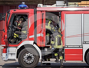 Italian firefighters climb on firetrucks