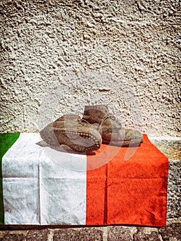 Italian flag and old worn soldier boots