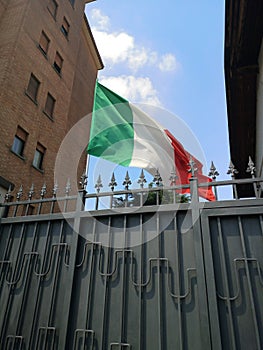 Italian flag over city houses