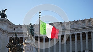 Italian flag waving against equestrian statue of Vittorio Emanuele II - Victor Emmanuel II at Piazza Venezia on sunny