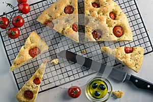 Italian focaccia bread homemade with rosemary, garlic, cherry tomatoes and olive oil.