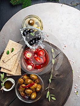 Italian food background, with bell peppers and green olives, stuffed with cheese, black olives, olive oil and green spruce or fir