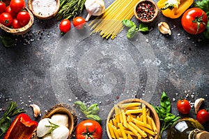 Italian food background. Pasta, herbs, vegetables on black top v