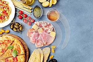 Italian food background. Pizza, pasta, cheese, hams, wine, pesto and capers