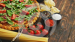 Italian food background with pizza, raw pasta and vegetables on wooden table