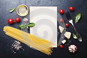 Italian food background with uncooked spaghetti, tomato, basil, cheese, garlic and olive oil or cooking pasta on table top view