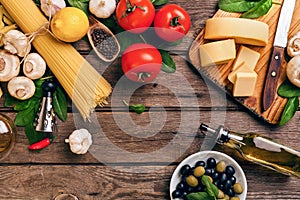 Italian food cooking-tomatoes, basil, pasta, olive oil and cheese on wooden background, top view, copy space.