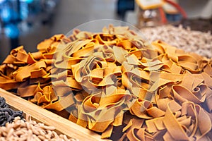 Italian food, dried handmade colorful pasta pappardelle with saffron, ready to cook, Milan, Lombardy, Italy photo