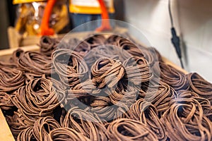 Italian food, dried handmade colorful pasta tagliatelle with added cacao, ready to cook, Milan, Lombardy, Italy photo