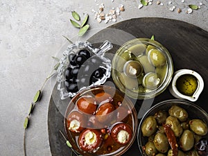 Italian food ingredients Black and green olives in glass bowls and olive oil, stuffed with cheese small bell peppers and red