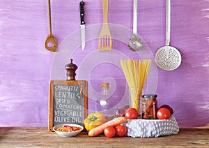 Italian food, ingredients for spaghetti dish with vegetables, red lentils and sun-dried tomatoes, recipe on kitchen black