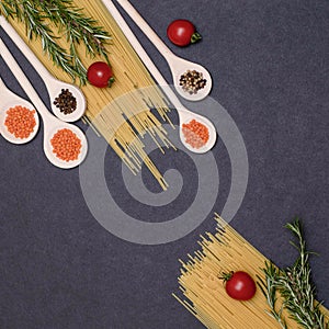 Italian food ingredients.Still life of cooking pasta on a black background top view. Wooden spoons with spices. Frame of products
