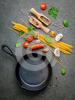 Italian food and menu concept. Spaghetti with ingredients sweet basil ,tomato ,garlic peppercorn and champignon on dark background
