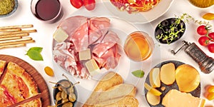Italian food panorama. Pizza, cheese, ham, wine, olives, capers, shot from above