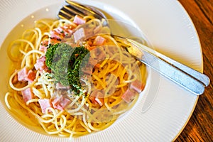 Italian food pasta with cheese sauce, Spaghetti carbonara with chopped bacon, cheese sauce on white dish over wooden table