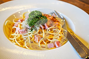 Italian food pasta with cheese sauce, Spaghetti carbonara with chopped bacon, cheese sauce on white dish over wooden table