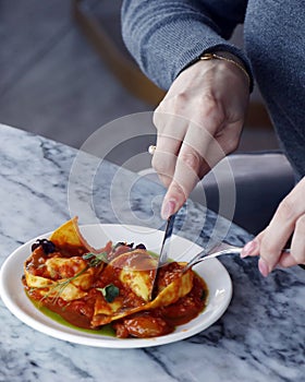 italian food pasta dish lobster stuffed ravioli with saffron tomato sauce in close up on a dining table