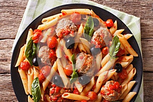 Italian Food: Pasta with meatballs, olives and tomato sauce closeup. Horizontal top view