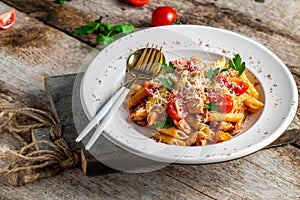 Italian food. Pasta penne with chicken meat, tomato sauce and vegetables served with parmesan cheese. Food recipe background