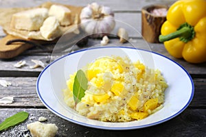 Italian food. Plate of yellow bell pepper risotto and grated parmesan cheese