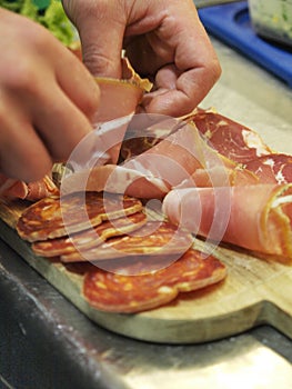 Italian food - Preparation of appetizer of Italian cold cuts, salami ham