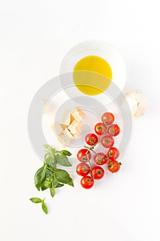 Italian food with red tomatoes, pasta, basil leafs, cheese, garlic, isolated on white background