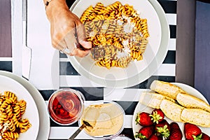 Italian food at restaurant or home viewed from above invertical pov - red colors for tomatoes sauce and maccheroni pasta with