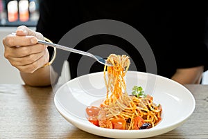 Italian food woman eating spaghetti with fork in the white plate