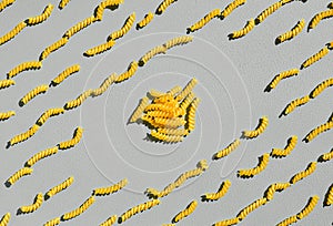 Italian fusilli, rotini or scroodle macaroni pasta food background texture. Top view, pasta spirals on gray background