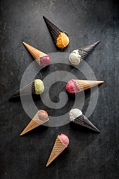 Italian gelato and sherbet in waffle cones on black background