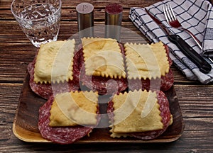 Italian Gnocco Fritto with salami on rustic wooden table. Substitute for bread made with fried dough photo