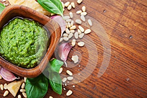 Italian green pesto sauce with ingredients top view. Healthy and organic food.