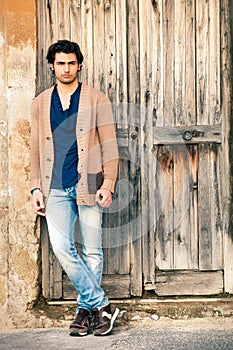 Italian handsome man model near an ancient wooden door