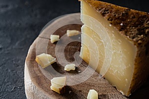 Italian hard cheese pecorino toscano chopped on wooden cut photo