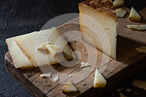 Italian hard cheese pecorino toscano sliced and chopped on wooden board photo