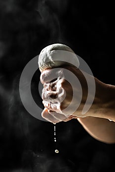 Italian hard cheese silano or caciocavallo in cheesemaker hands. The process of making homemade mozzarella. Cheesemaker, showing