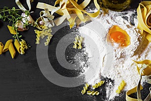 Italian homemade pasta with wheat flour and egg on black background