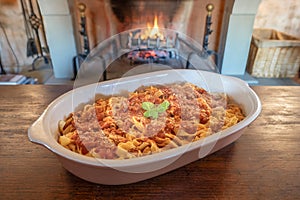 Italian homemade tagliatelle noodles with tomato sauce on a wooden table