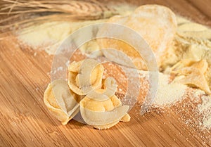 Italian homemade tortellini with flour,raw dough,ear of wheat and a heart shaped ravioli.
