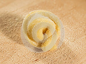 Italian homemade tortellino placed on wooden table,sprinkled with flour. photo
