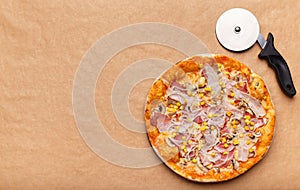 Italian Hot Pizza And Cutter On Craft Paper Background