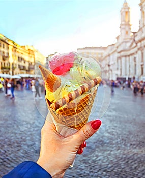 Italian ice - cream cone held in hand on the background of Piazza Navona