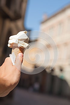 Italian ice cream cone in hand on the background Padua streets , Italy