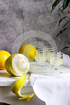 Italian liqueur limoncello in crystal glasses and ripe lemons on a wooden table