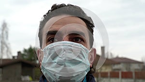 Italian man in medical mask outdoors looking scared shocked and frustrated