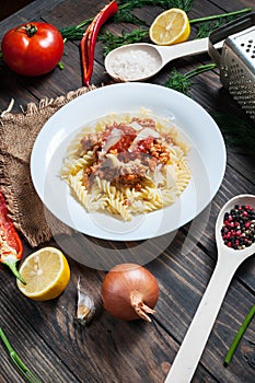 Italian meat sauce pasta and fresh delicious ingredients for cooking on rustic background