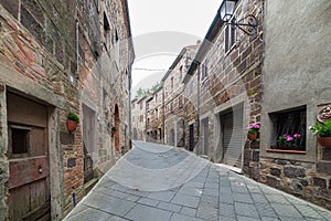Italian medieval village details, historical stone alley, ancient marrow street, old city stone buildings architecture. Radicofani