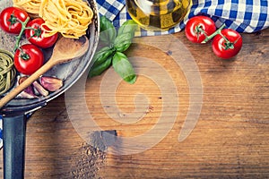 Italština a středomoří jídlo složení na dřevěný. třešeň rajčata těstoviny bazalka listy a karafa olivový olej 