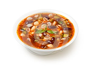 Italian minestrone soup in a white porcelain soup bowl isolated on a white background.